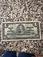 Front side of 1937 Bank of Canada one dollar bill showing King George VI portrait and bilingual denomination text.