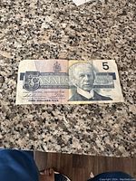 Front side of the 1986 Canadian $5 bill showing Sir Wilfrid Laurier's portrait and denomination 5.
