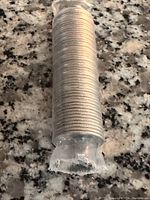Full roll of tightly wrapped 2001 dimes on a granite counter surface.