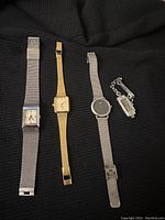 Four wristwatches laid out showing different styles and bands