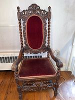 Full front view showing carved frame, twisted supports, velvet seat and back pad