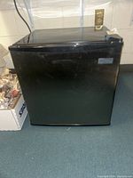 Photo of the black mini fridge showing its full front view and overall condition.