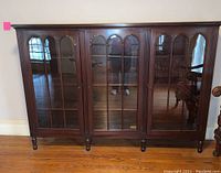 Front view showing entire bookcase with three glass doors and turned legs
