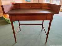Front view of desk showing curved back and black writing surface