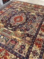 Full-field view of rug laid flat on showroom floor showing overall color scheme and central medallion.