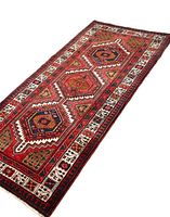 Full view of the handmade Sarab runner rug showing the geometric design with three large central medallions and surrounding floral and geometric border patterns in red, brown, black, white and blue.