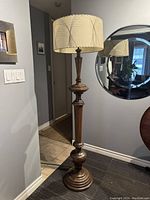 Full view of the Victorian style mahogany floor lamp standing in a room with painted walls, showcasing the entire lamp including base, column, and lampshade.