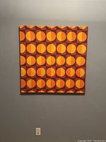 Front view of square canvas painting mounted on wall showing full geometric circle pattern.