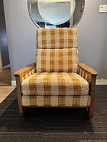 Front view of the lounge chair showing teak wood arms and patterned upholstery