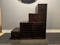 Front view showing stepped design, louvered doors and drawers