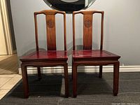 Two chairs front view showing carved back splats and seat panels