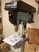 Front view of Delta 16½" drill press showing head, table, chuck and lever assembly
