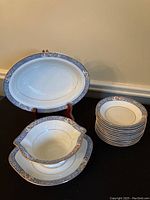 Photo showing oval vegetable bowl on stand, gravy boat with underplate, and stack of 12 fruit nappies.