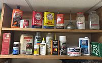 Photo showing vintage oil cans including Toronto Elevators linseed oils, Moto-Master hand cleaner, Monarch coal oil and various smaller bottles and cans of lubricants and cleaning products.
