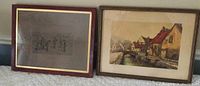Photo of two framed prints, showing the rural waterway scene on right and a sketch print on left in maroon frame
