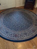 Overview of the circular carpet placed on wooden floor showing overall pattern and color.