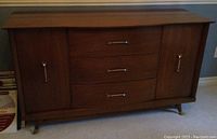 Full view of the walnut buffet showing 3 drawers in the center and 2 cabinets on either side with metal handles, short legs at the base.