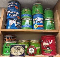 Overview photo of vintage cans on wooden shelves including Maxwell House, Sail, Velvet, British Consols, and Scotch tins