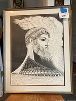 Full view of the framed black and white print depicting a classical bearded head and Montreal Olympic Stadium inspired architecture.