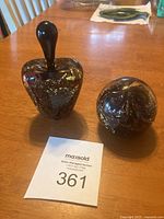 Photo showing both the perfume bottle with stopper and the matching paperweight on a wooden table, alongside a lot number card.