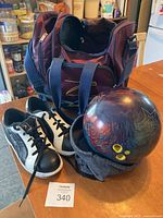 Photo showing the bowling bag, bowling ball with finger holes, and black and white bowling shoes size 8 on the floor.