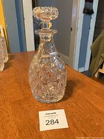 Full view of the pineapple shaped cut crystal decanter with stopper showing the diamond cut pattern and overall shape.