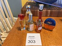 Top view of six assorted small perfume and cologne bottles arranged on wooden table
