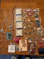 Overview photo of the costume jewelry laid out on a table showing various necklaces, earrings, packaged beads, and bracelets.