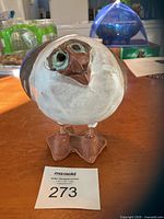 Front view of signed puffin bird pottery sculpture showing the detailed bird face and feet.