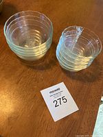 Top view showing four larger clear glass Pyrex bowls on left, five smaller Pyrex bowls on right on table
