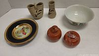 Full lot view showing beige ceramic vases, orange lidded pots, Chokin gold plate and white ceramic bowl