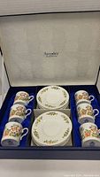 Boxed set of six Aynsley espresso cups and saucers inside original box with satin blue lining.