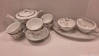 Full set of Noritake tea items including teapot, cups, saucers, creamer, sugar bowl, and Val serve plate arranged in a group
