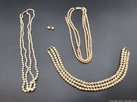 Three pearl necklaces and one pair pearl earrings laid out on black background. The triple-strand pearl necklace has a 925 silver clasp. Two single-strand pearl necklaces visible, one in photo appears in good shape, but two need repairs according to seller. Pearl stud earrings positioned near necklaces.