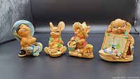Four Pendelfin figurines displayed together showing beach themes