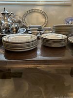 View of the stacked plates on a table, silver tea set visible in background