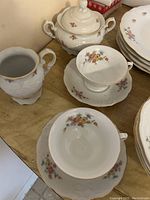 Fine china creamer, sugar bowl with lid, two teacups and saucers with rose floral decal pattern