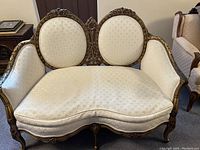 Front view of French Provincial 2-seater loveseat showing carved wood frame and cream fabric upholstery with subtle pattern