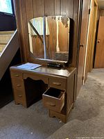 Front view of the vintage wooden vanity with attached mirror and drawers open showing condition and style.