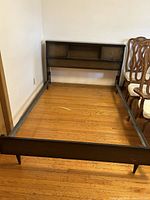 Wood veneer double size bed frame without mattress. The bed frame includes the footboard and headboard, the latter with sliding drawers visible on front side.