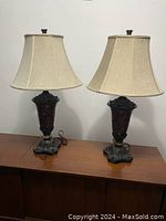 Pair of lamps with beige lampshades showing mosaic base unlit