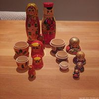 Front view of all wooden Russian nesting dolls and salt/pepper shakers arranged on a wooden table