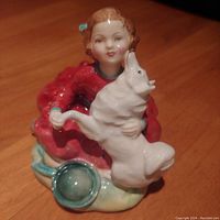 Angle showing the girl's face and dog in a hugging pose with green bowl at base