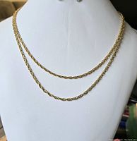 Two gold toned twisted rope chains displayed on white bust stand, one shorter (16 inch) and one longer (18 inch).