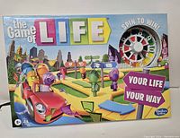 Photo of the front of The Game of Life board game box, showing colorful graphics and spin wheel illustration.