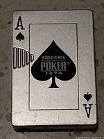 Front view of the pocket lighter showing the Ace of Spades playing card with World Series of Poker logo.