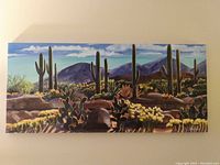 Full view of the horizontal canvas painting showing desert landscape with cacti and mountains