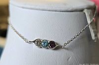 Sterling silver bracelet on display stand showing the full piece including delicate chain and central stone bar