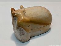 Closed view of the hand-carved stone hippopotamus box showing shape and coloration.