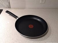 Full view of black non-stick frying pan with handle, showing the pan's cooking surface and handle design.